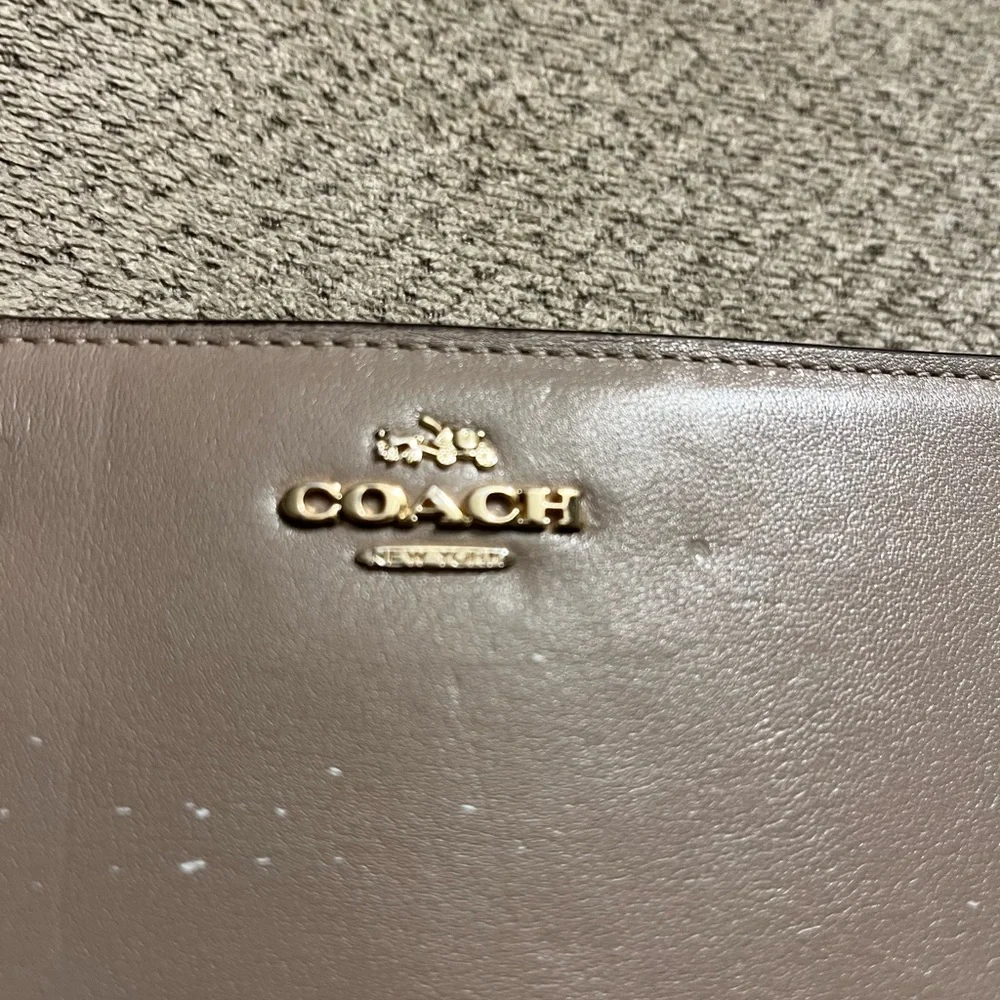 Coach wallet. Has some wear marks and wrinkles on outside of wallet.